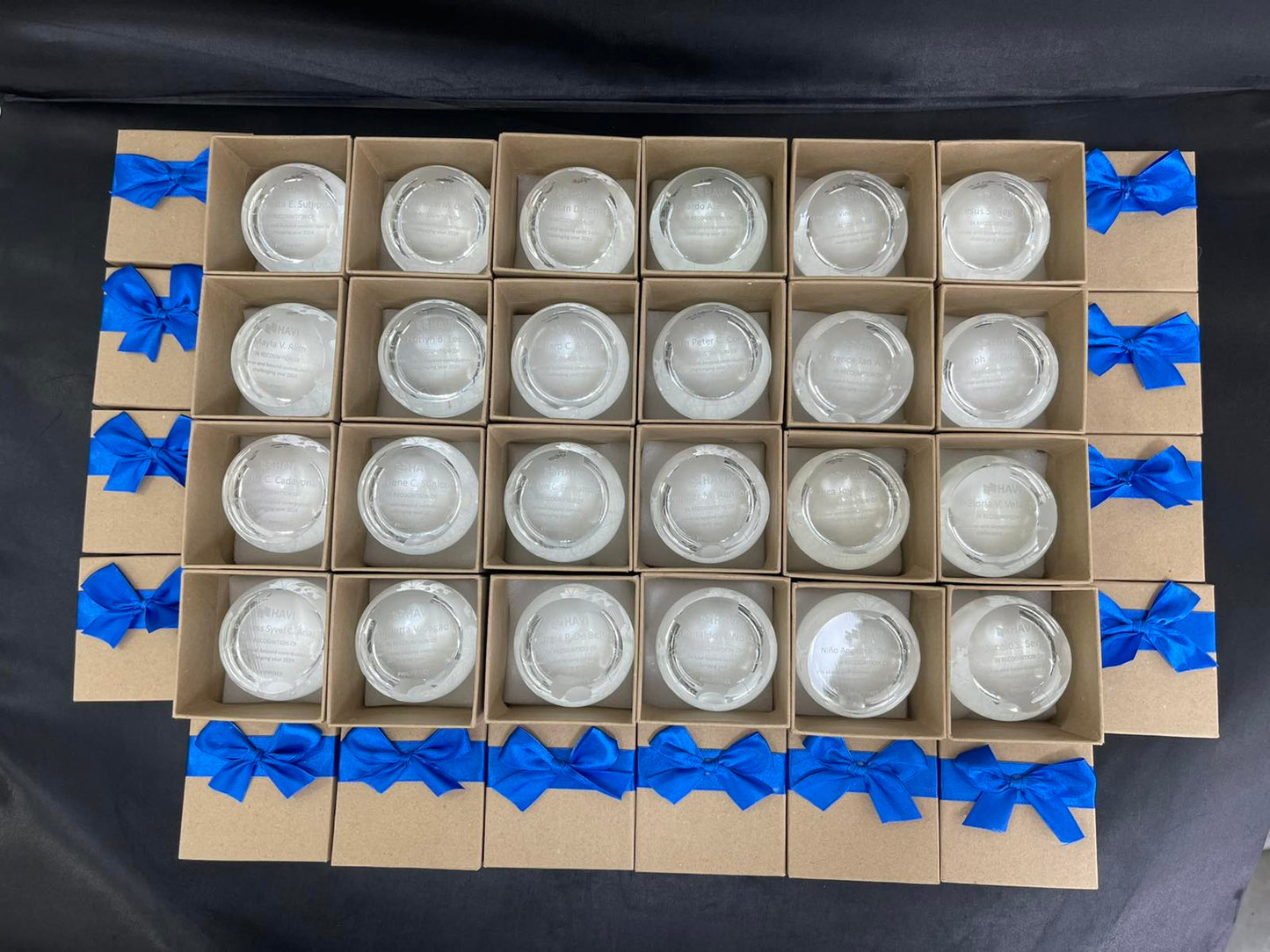 Cardboard boxes with crystal desk trophies blue ribbons on a black background