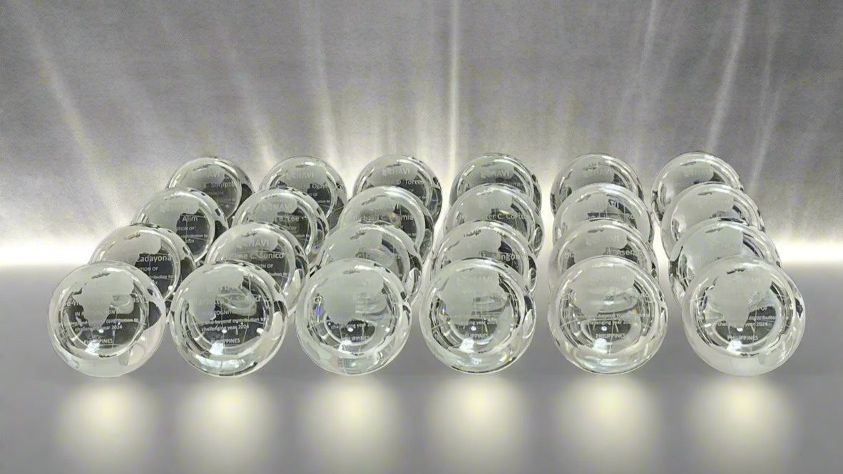 Multiple clear crystal desk globe trophies stacked on a black background