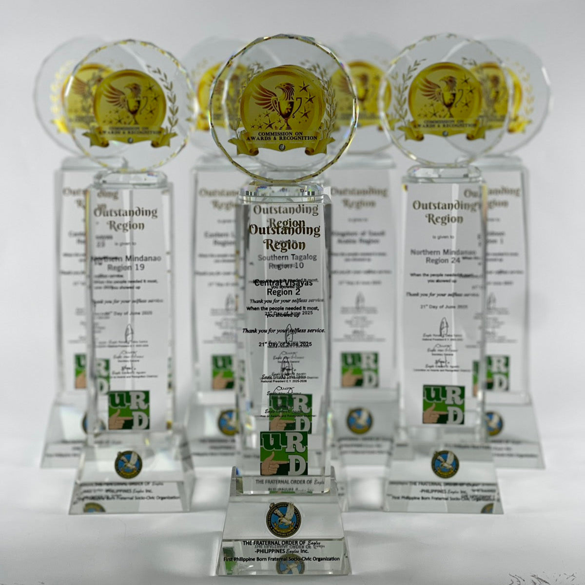 Set of clear awards with engraved text and logos on a white background