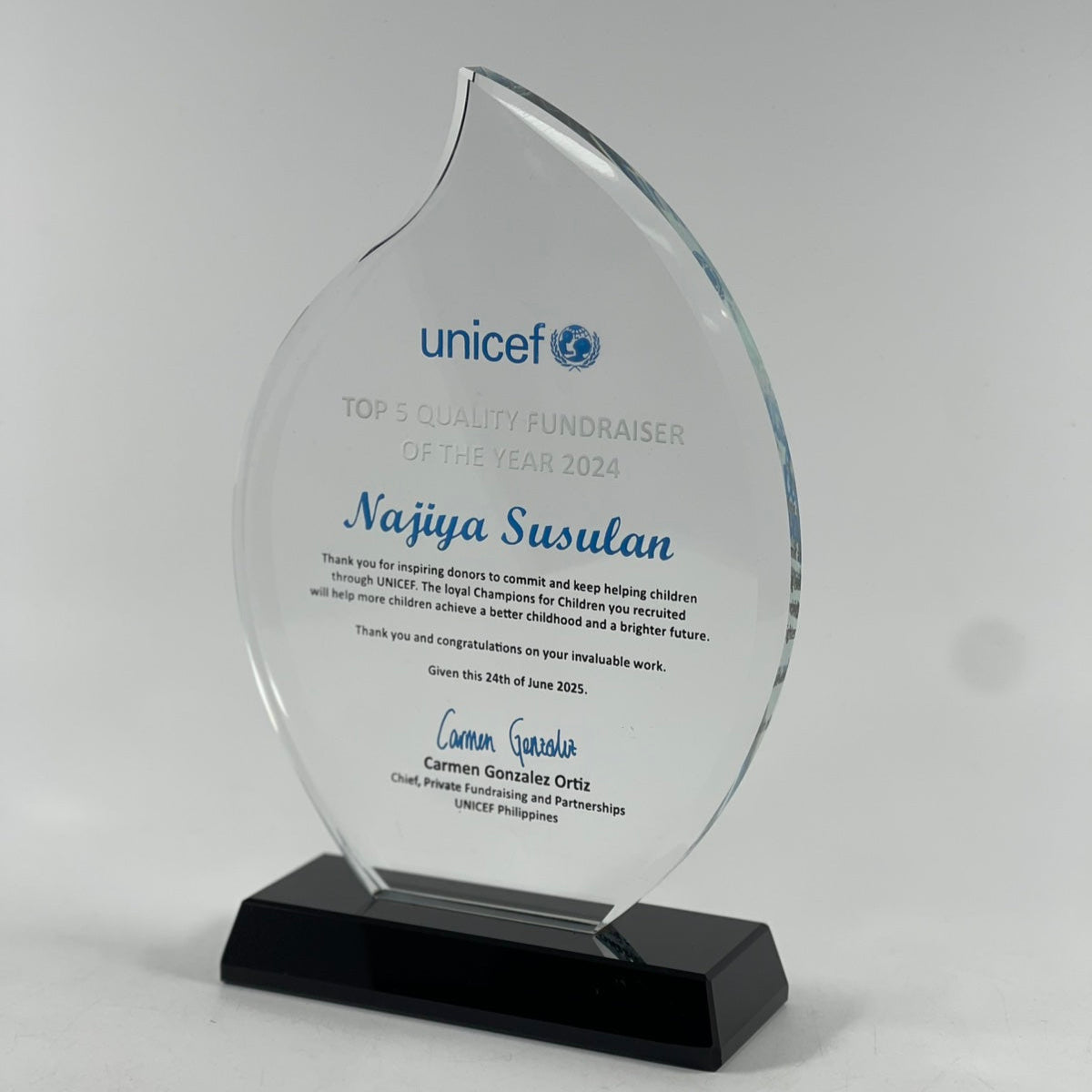 Glass award with UNICEF logo and text on a white background