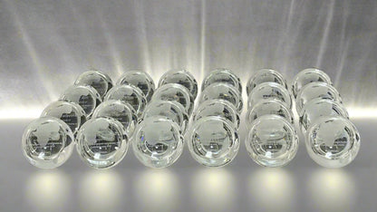 Multiple clear crystal desk globe trophies stacked on a black background