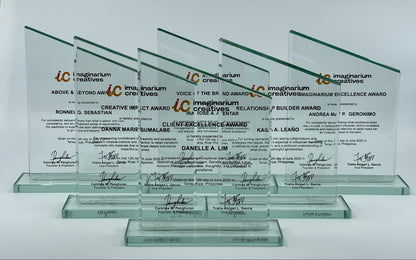 Set of glass awards with engraved text and signatures on a white background