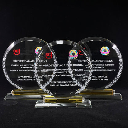 Three round glass awards with text and logos on a black background